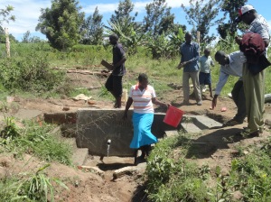 Collecting water form the new spring station in Kamburu